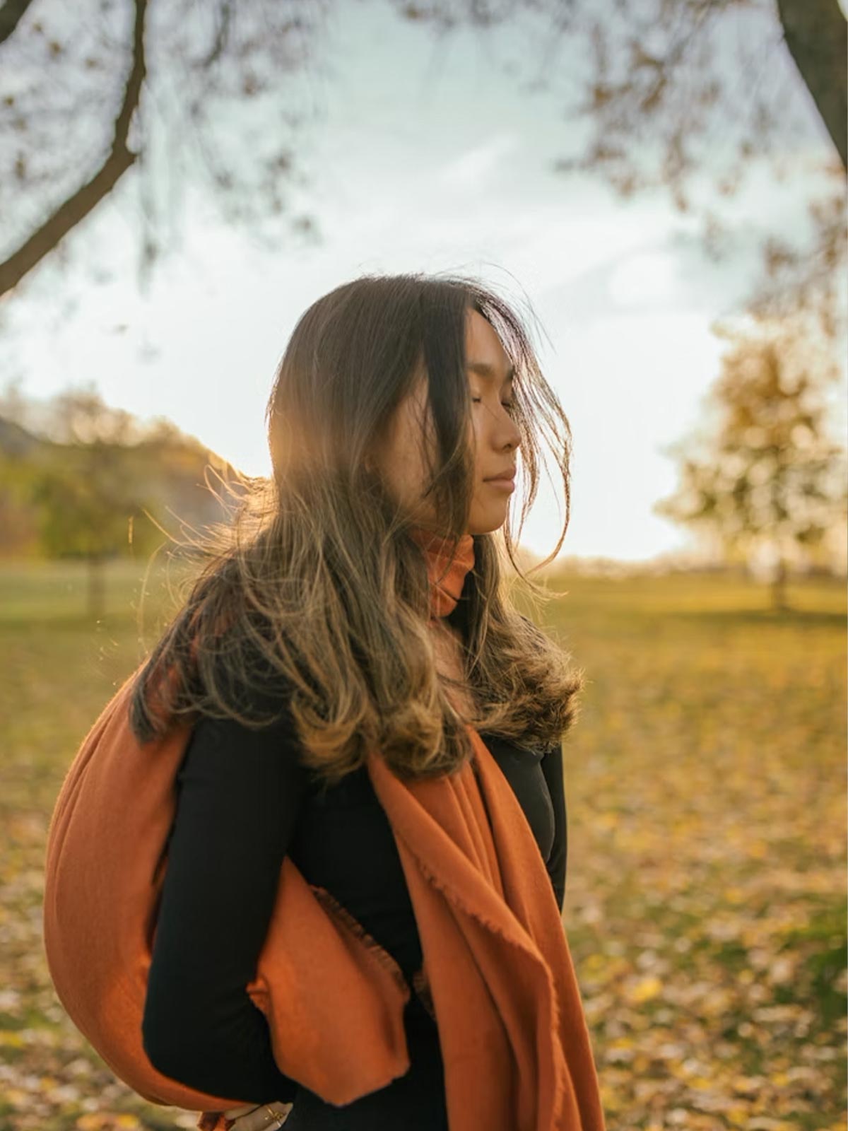 Frau in der Natur bei Sonnenuntergang – Sinnbild für Ruhe, Gelassenheit und Resilienz durch Ashwagandha Kapseln von Kurkraft.