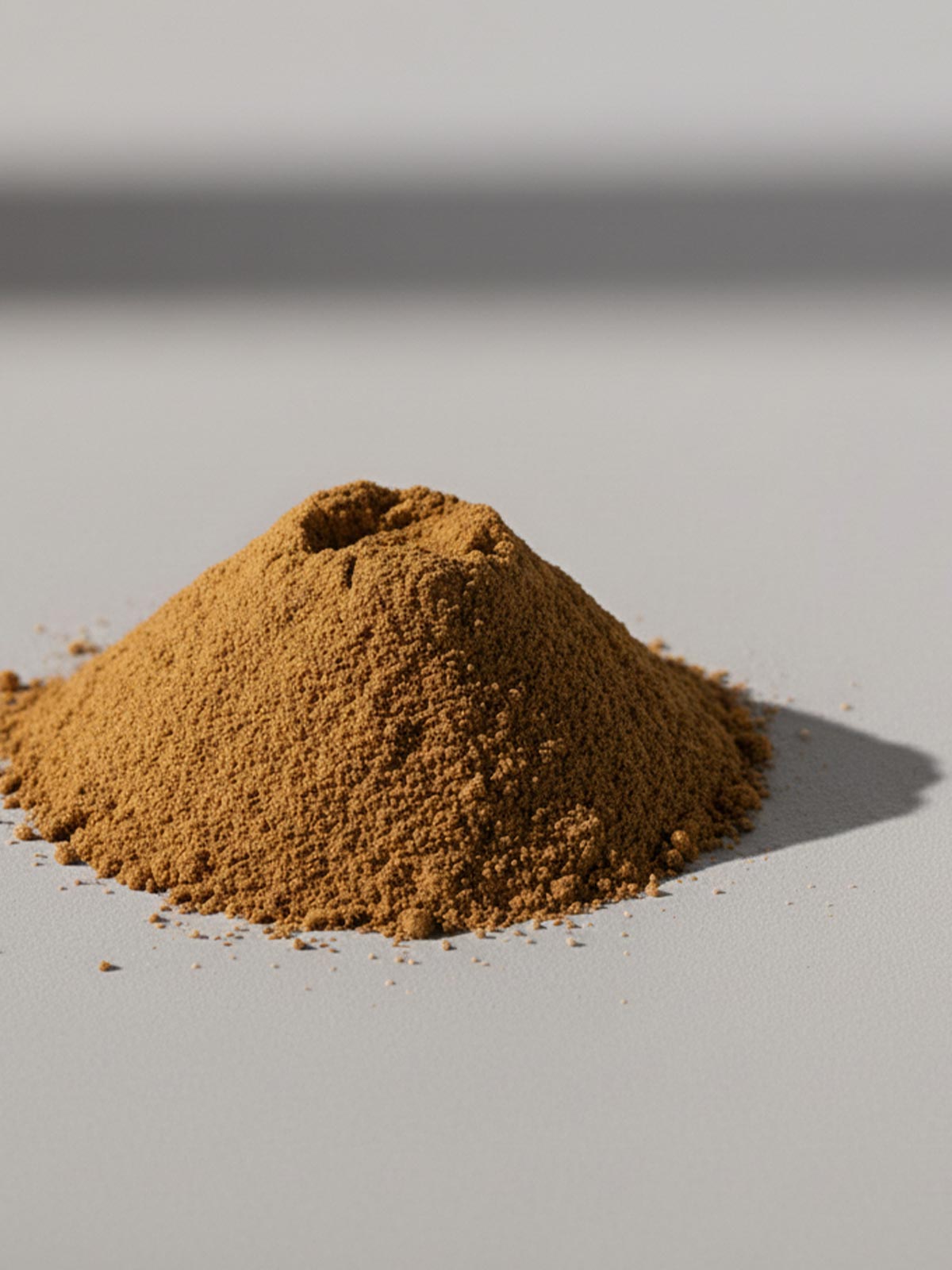 Triphala Pulver auf heller Oberfläche – natürliche Mischung aus Amalaki, Haritaki und Bibhitaki